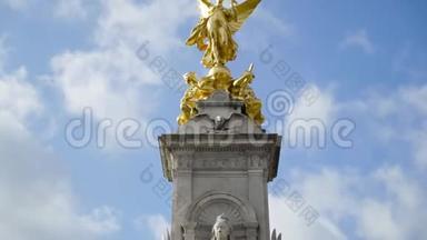 维多利亚纪念碑在白金汉宫的蓝云背景。 行动。 白金汉宫前维多利亚女王纪念碑